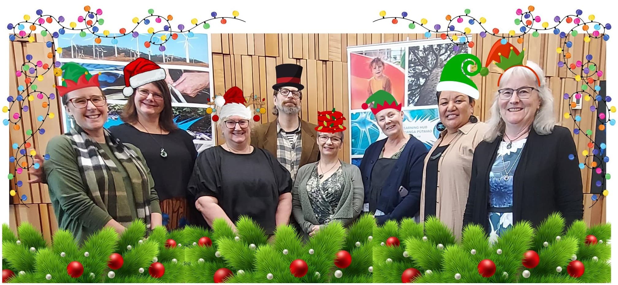 Group of 8 people with Christmas hats.